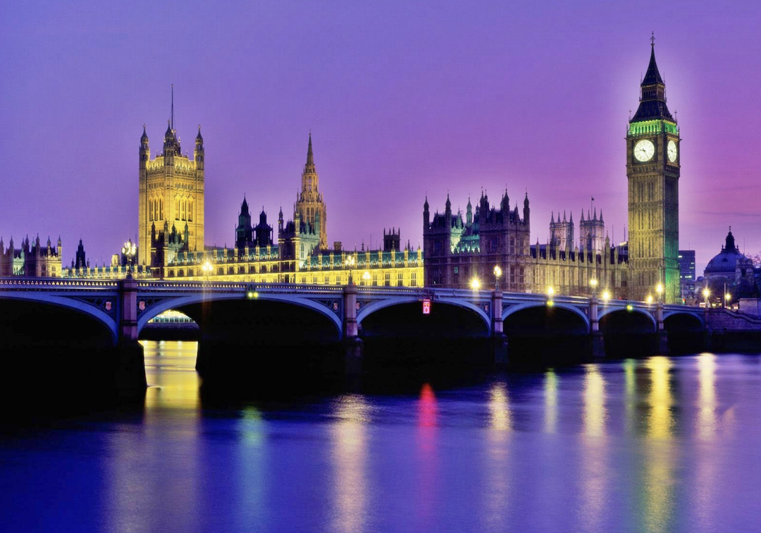 Un autobús rojo de dos pisos pasando por el Big Ben en Londres